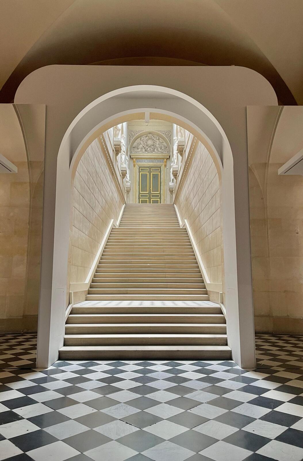 Stone stair hall with arched opening and classical architectural detail